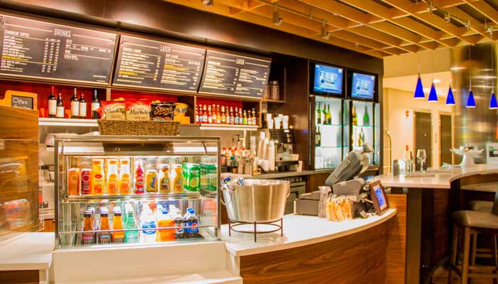 A modern coffee shop counter at Sundrift Inn Panama City Beach Hotel with menus and barista gear.