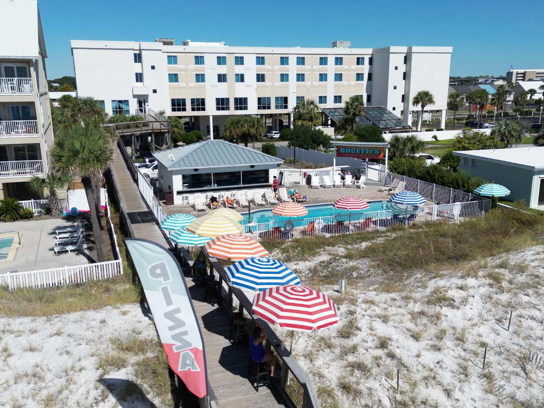 A beachside pool area with colorful umbrellas at Sundrift Inn, steps from the boardwalk and shore.
