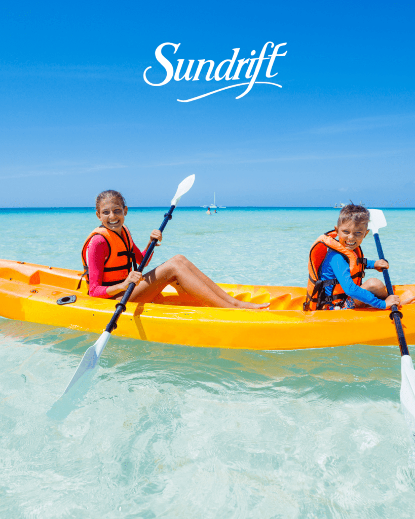 Kids kayaking in clear emerald water near Okaloosa Island at Sundrift Inn in Fort Walton Beach Florida on the Emerald Coast