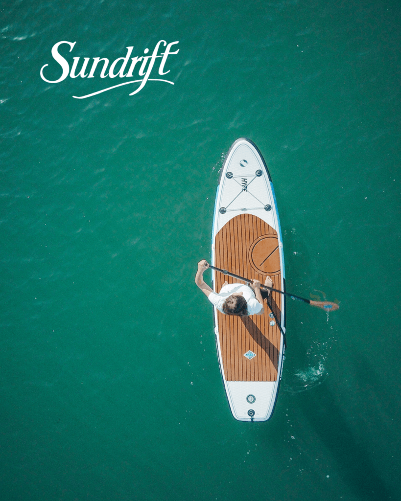 Paddleboarder on clear emerald water near Okaloosa Island beach at Sundrift Inn in Fort Walton Beach Florida
