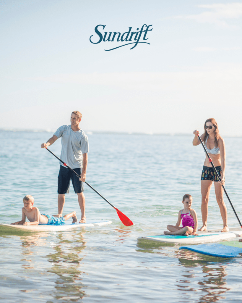 Family paddleboarding in the Gulf of America in front of Sundrift Inn on Okaloosa Island in Fort Walton Beach Florida