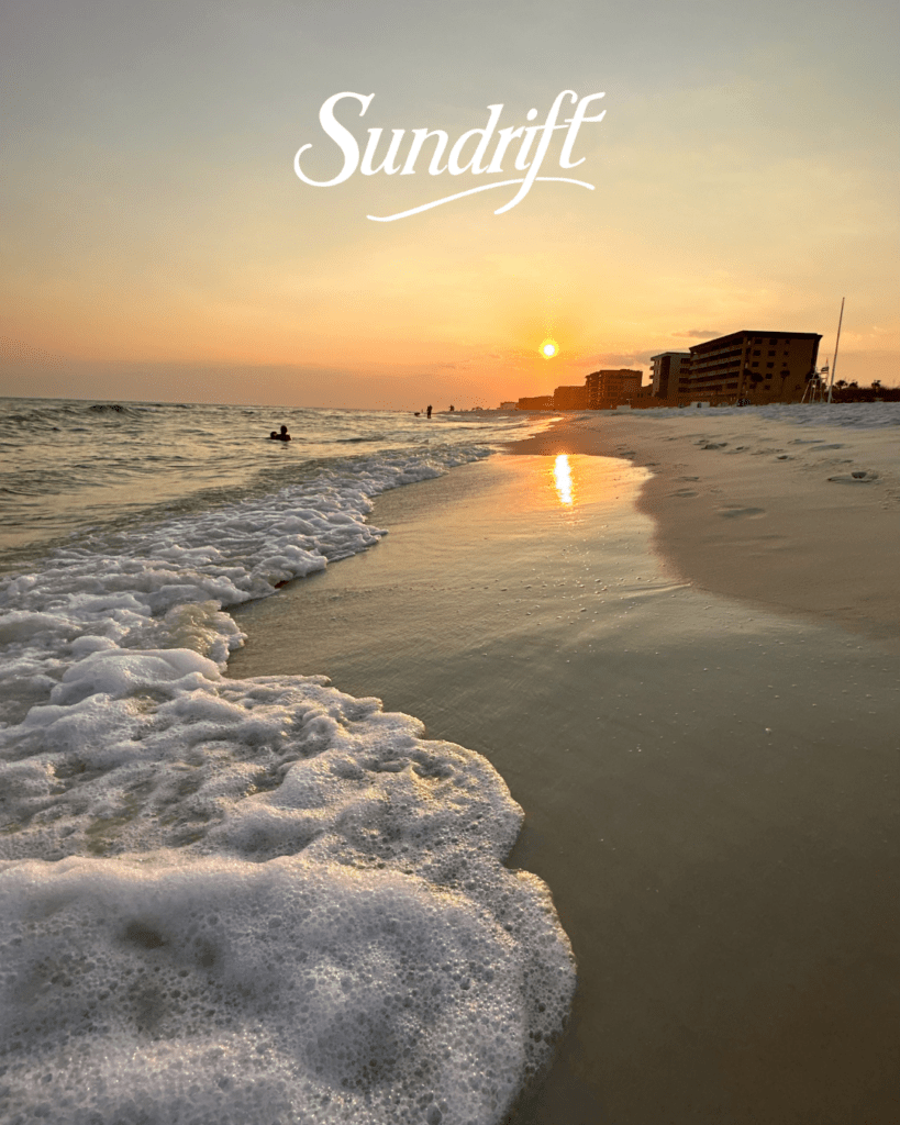 Sunset over the beach at Sundrift on Okaloosa Island with waves rolling onto the shore along the Emerald Coast