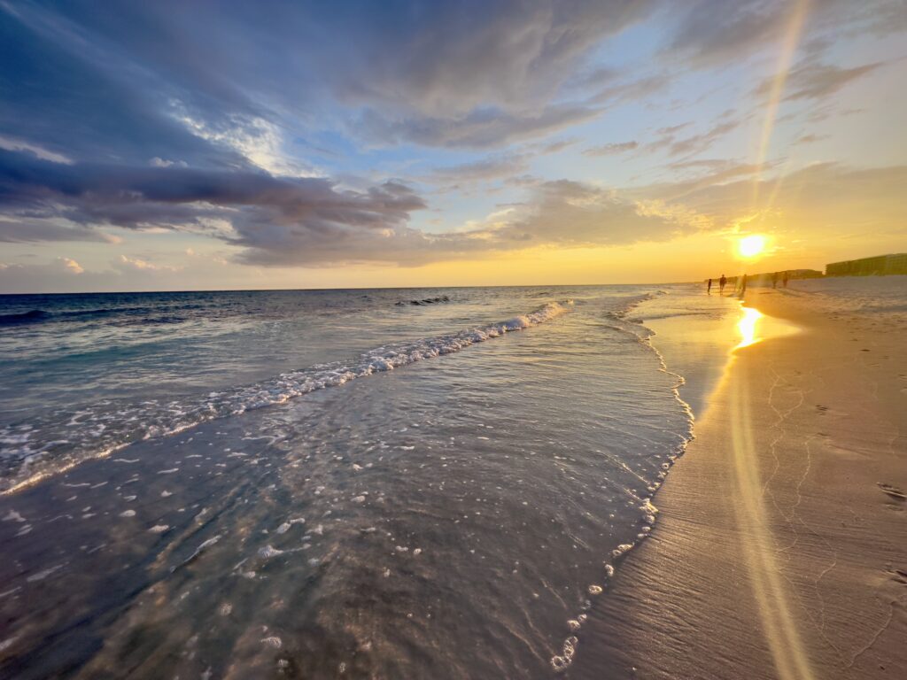 Sunset over the beach on Okaloosa Island with waves rolling onto the shore along the Emerald Coast in Florida