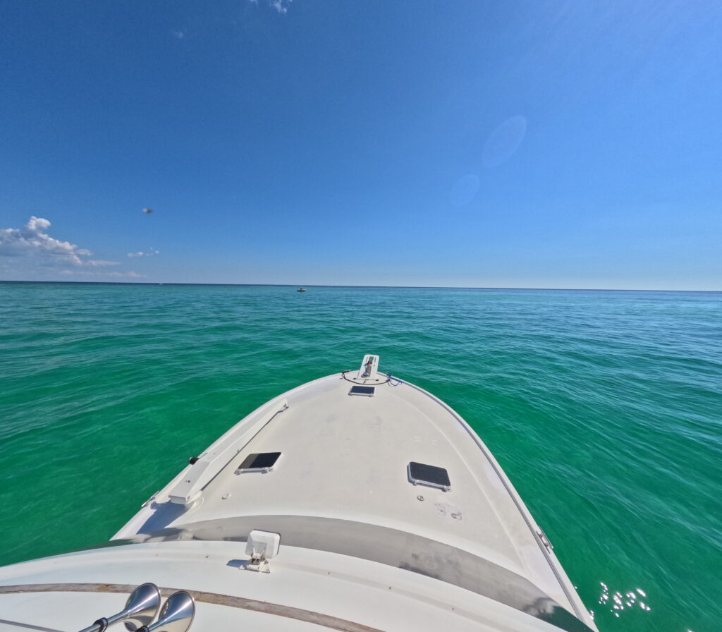 Boat view cruising emerald water near Okaloosa Island during a Destin dolphin charter on the Emerald Coast