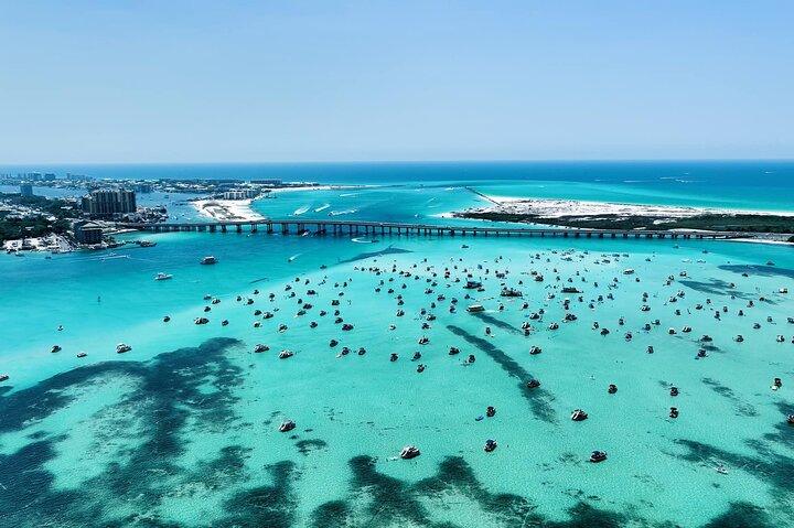 Aerial view of Crab Island near Destin, Florida with boats anchored in clear emerald water on the Emerald Coast