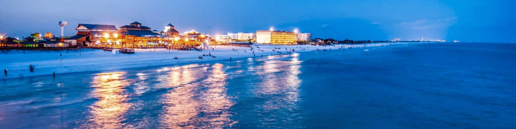 Okaloosa Island Fishing Pier at sunset with waterfront lights reflecting on the Gulf in Fort Walton Beach Florida