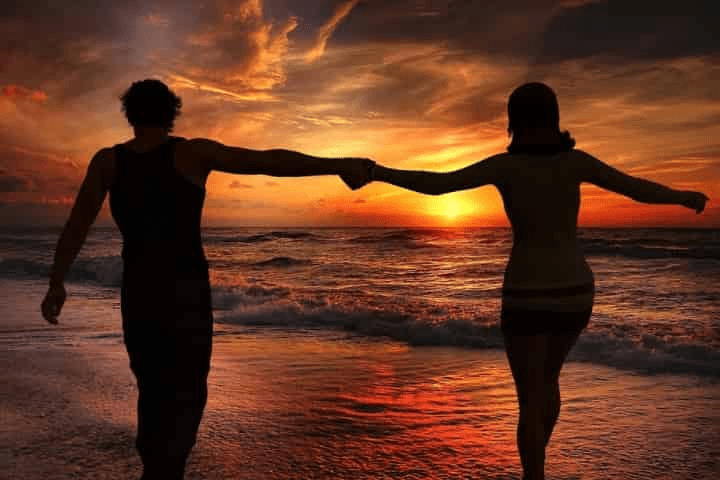 Couple walking along the beach at sunset on Okaloosa Island in Fort Walton Beach Florida