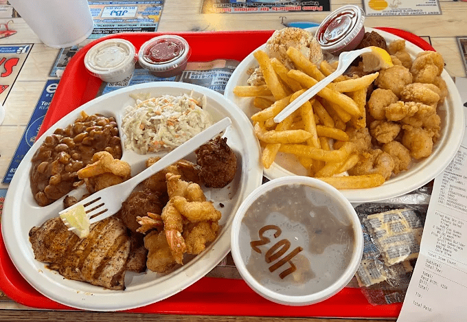 Fresh Gulf seafood platter from Stewby’s Seafood Shanty with fried fish, shrimp, hush puppies, fries, and coleslaw near Okaloosa Island in Fort Walton Beach Florida