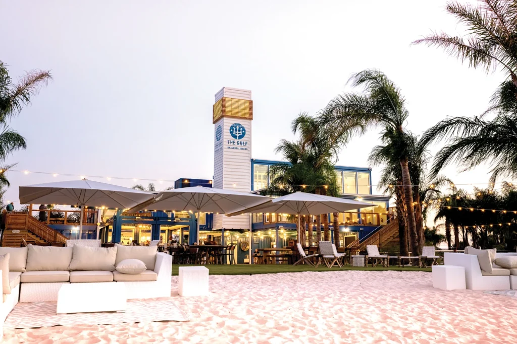 The Gulf restaurant on Okaloosa Island at sunset with outdoor seating and palm trees