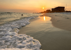 Sunset on Okaloosa Island beach in Fort Walton Beach Florida with waves and shoreline