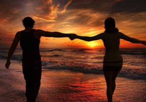 Couple walking along the beach at sunset on Okaloosa Island in Fort Walton Beach Florida